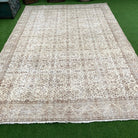 Brown 8' x 11' vintage Turkish floral rug in wool and cotton, shown on the floor.