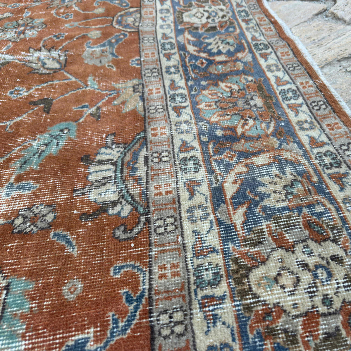 Close-up of the red vintage Turkish floral rug showing floral details, hand-knotted weave, wool and cotton and low pile.