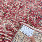 Close-up of the red vintage Turkish floral rug showing floral details, hand-knotted weave, wool and cotton and low pile.