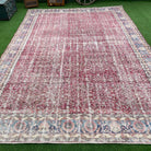Red 9' x 13' vintage Turkish floral rug in wool and cotton, shown on the floor.