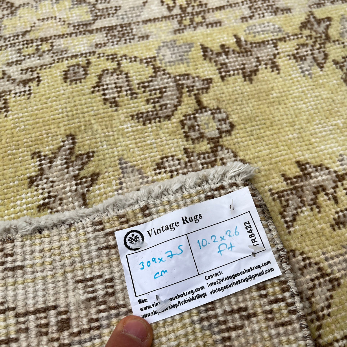 Close-up of the yellow vintage Turkish floral runner rug showing floral details, hand-knotted weave, wool and cotton and low pile.
