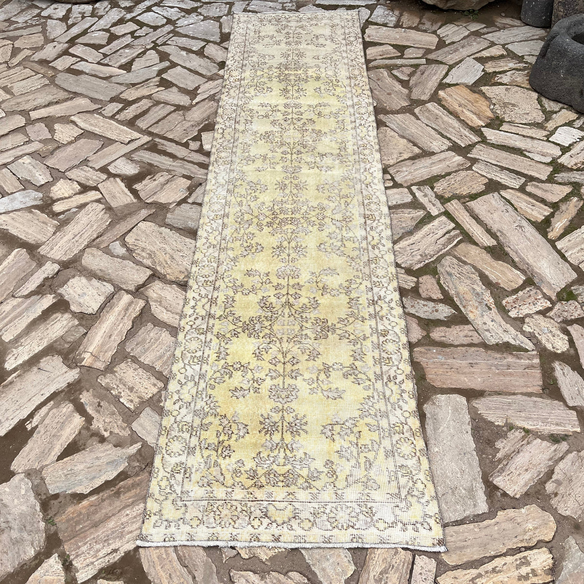 Yellow 2' x 10' vintage Turkish floral runner rug in wool and cotton, shown on the floor.