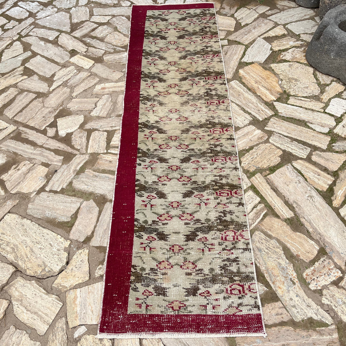 Beige 2' x 8' vintage Turkish floral runner rug in wool and cotton, shown on the floor.