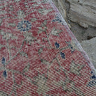 Close-up of the pale red vintage Turkish floral runner rug showing floral details, hand-knotted weave, wool and cotton and low pile.