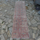Pale Red 2' x 8' vintage Turkish floral runner rug in wool and cotton, shown on the floor.