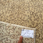 Close-up of the beige vintage Turkish floral runner rug showing floral details, hand-knotted weave, wool and cotton and low pile.