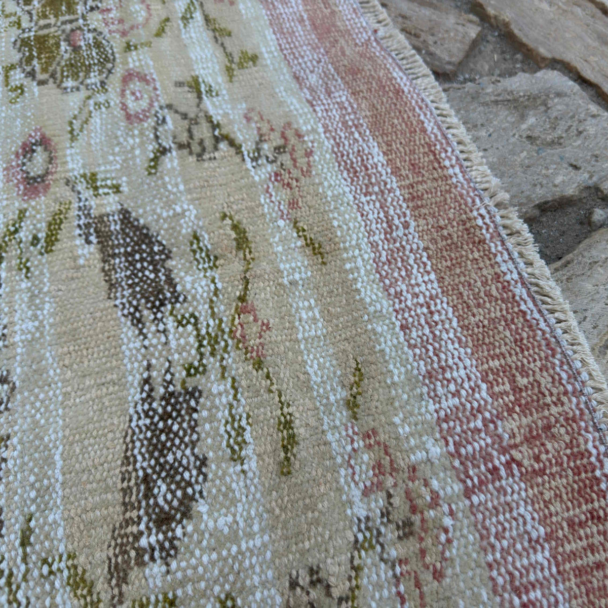 Close-up of the beige vintage Turkish floral runner rug showing floral details, hand-knotted weave, wool and cotton and low pile.