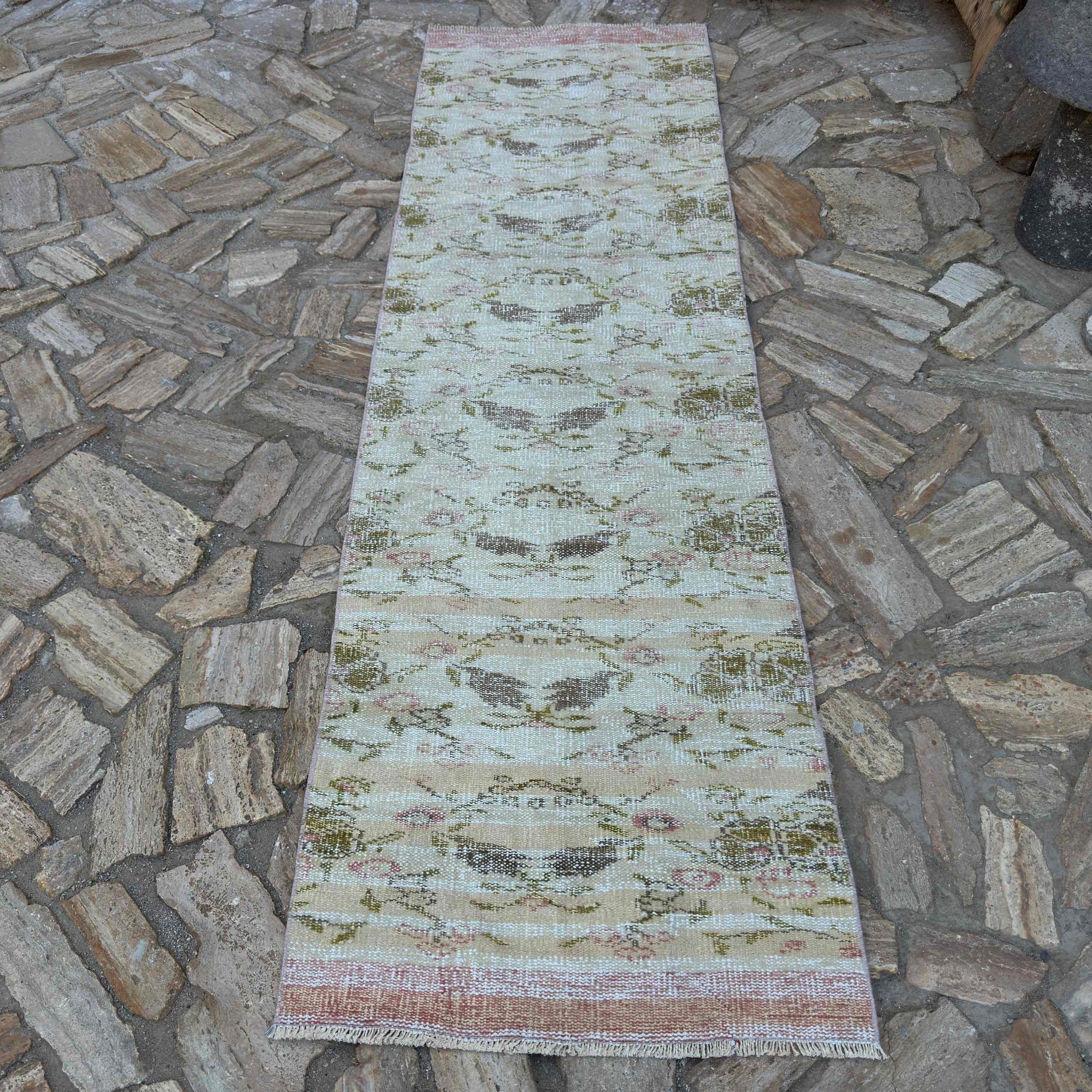 Beige 3' x 9' vintage Turkish floral runner rug in wool and cotton, shown on the floor.