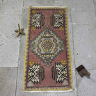 Pink 2' x 3' vintage Turkish geometric carpet in wool and cotton, shown on the floor.