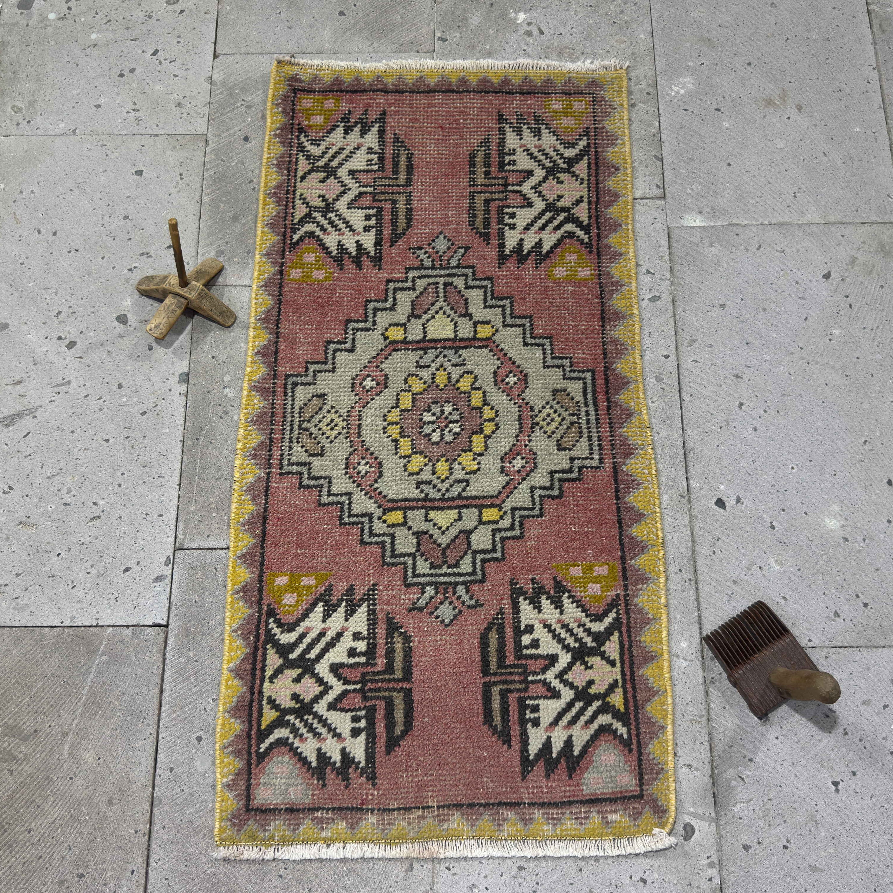 Pink 2' x 3' vintage Turkish geometric carpet in wool and cotton, shown on the floor.