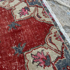 Close-up of the red vintage Turkish geometric rug showing traditional details, hand-knotted weave, wool and cotton and low pile.