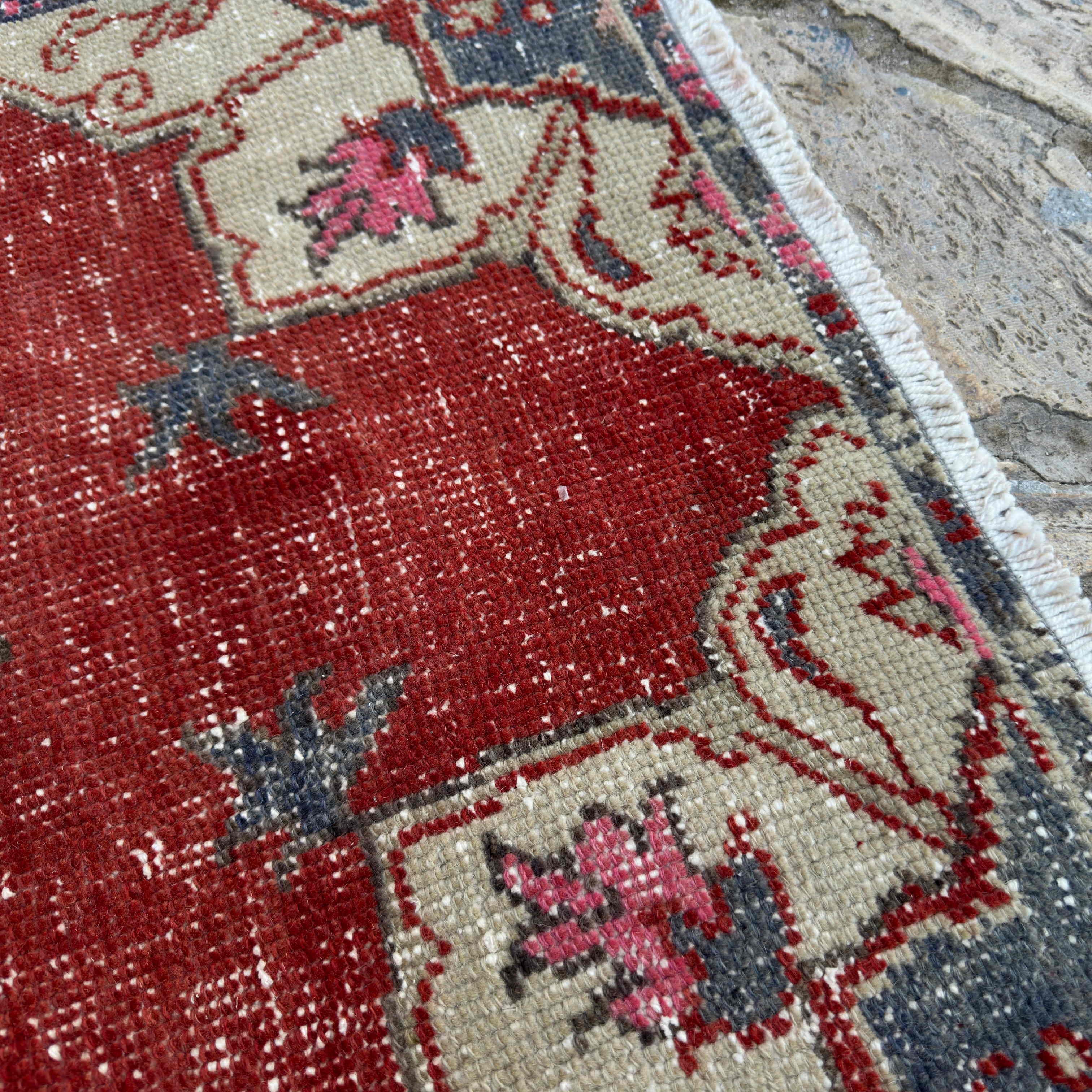 Close-up of the red vintage Turkish geometric rug showing traditional details, hand-knotted weave, wool and cotton and low pile.