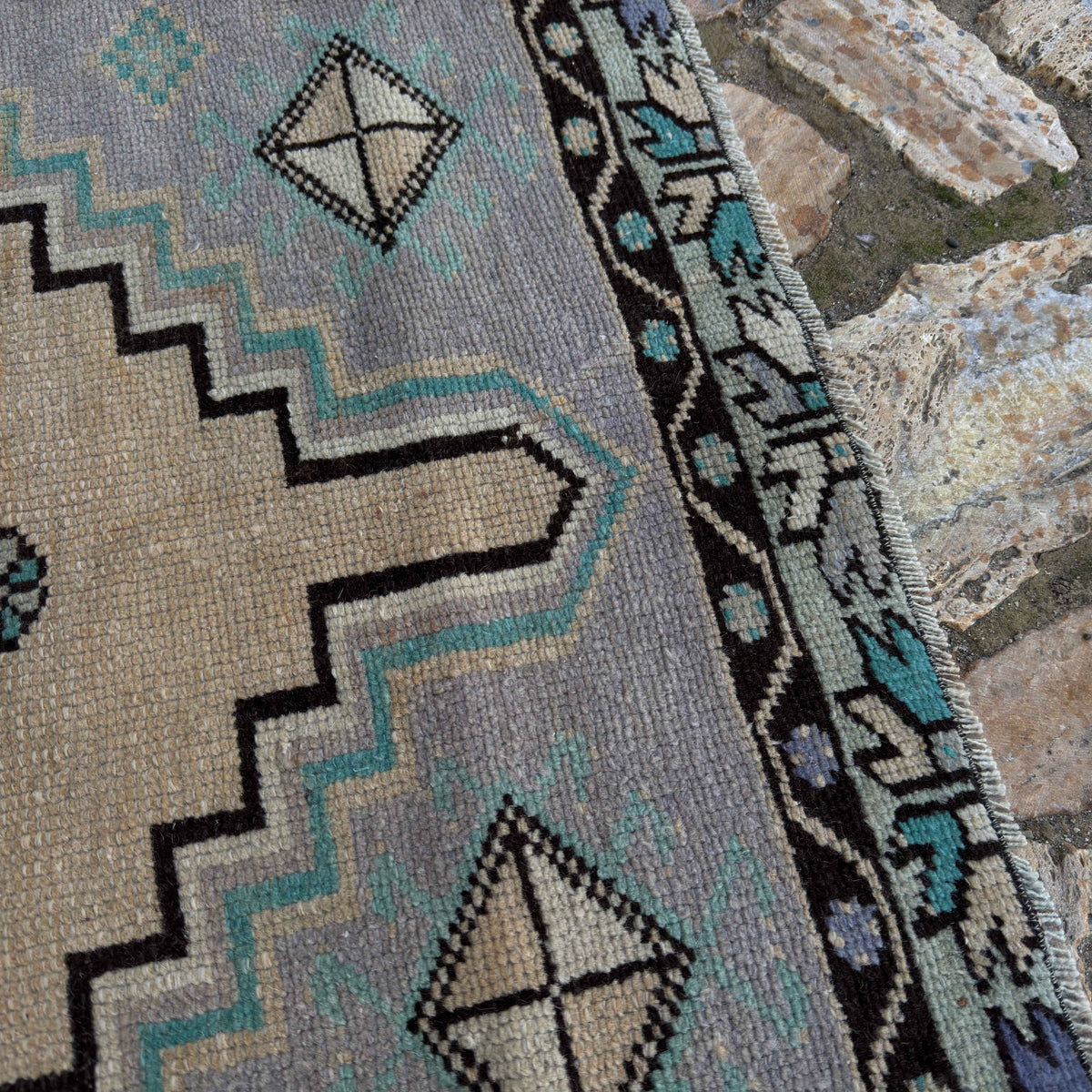 Close-up of the pale purple vintage Turkish geometric rug showing medallion details, hand-knotted weave, wool and cotton and low pile.