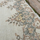 Close-up of the pale green vintage Turkish geometric rug showing medallion details, hand-knotted weave, wool and cotton and low pile.