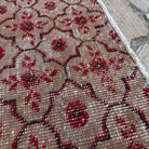 Close-up of the red vintage Turkish geometric rug showing geometric details, hand-knotted weave, wool and cotton and low pile.