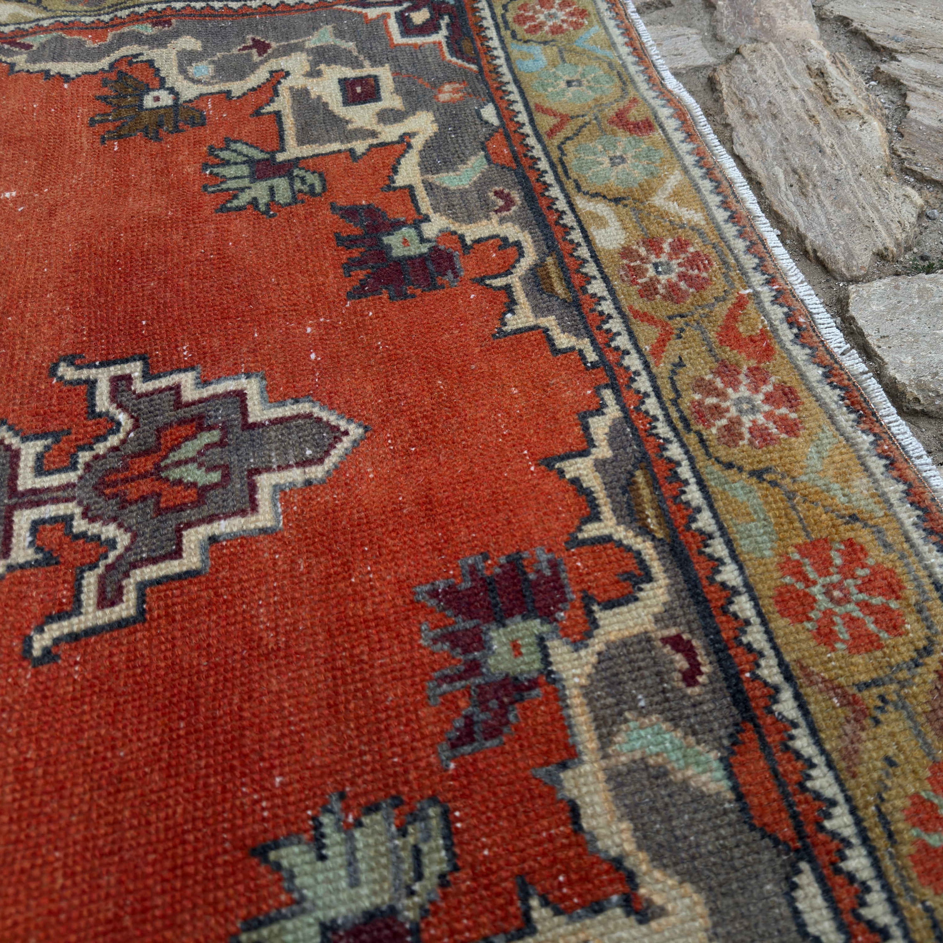 Close-up of the orange vintage Turkish geometric rug showing traditional details, hand-knotted weave, wool and cotton and low pile.