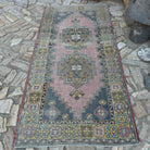 Pink 4' x 8' vintage Turkish geometric rug in wool and cotton, shown on the floor.
