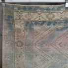 Close-up of the pale blue vintage Turkish geometric rug showing neutral details, hand-knotted weave, wool and cotton and low pile.