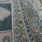 Close-up of the pink vintage Turkish geometric rug showing traditional details, hand-knotted weave, wool and cotton and low pile.