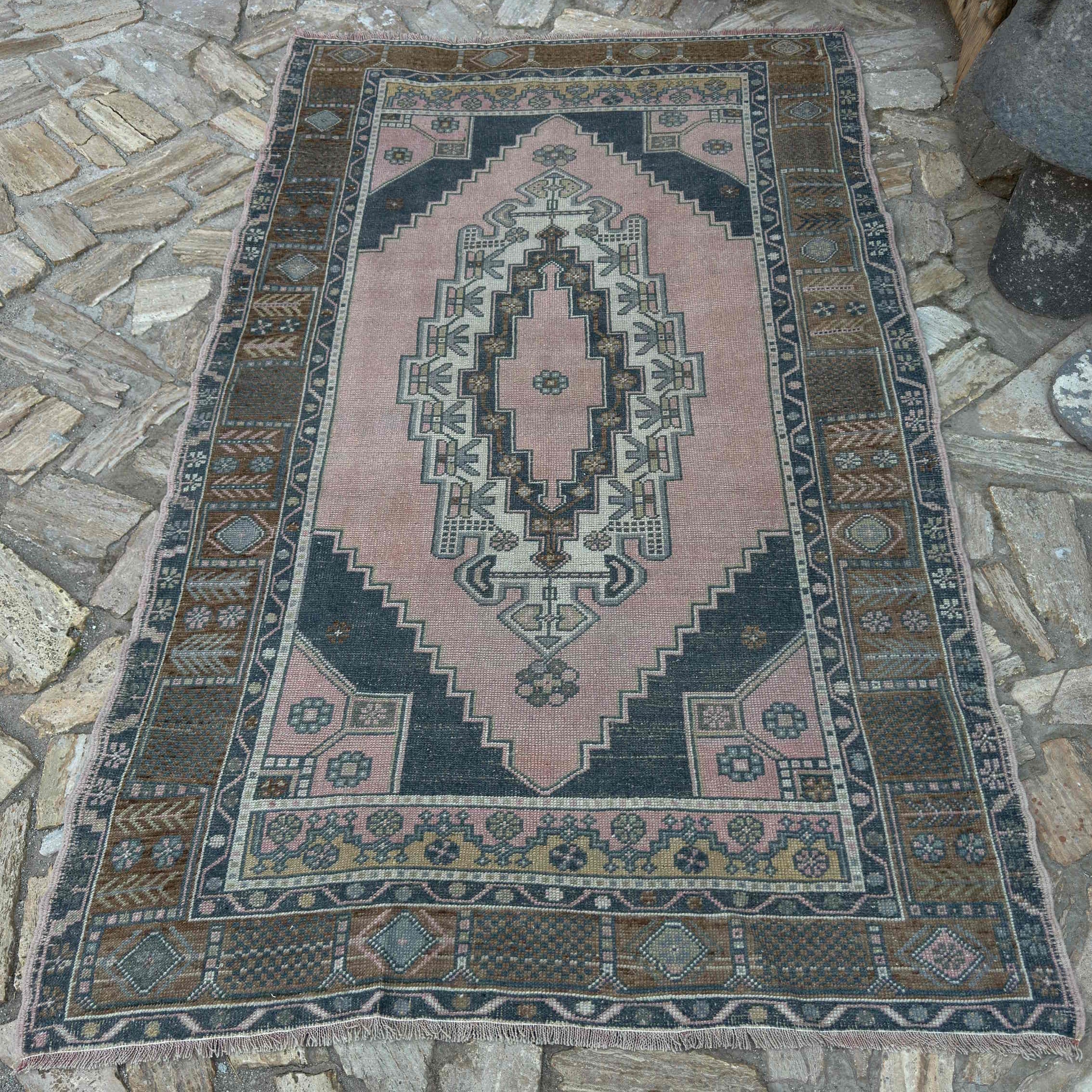 Pink 5' x 8' vintage Turkish geometric rug in wool and cotton, shown on the floor.