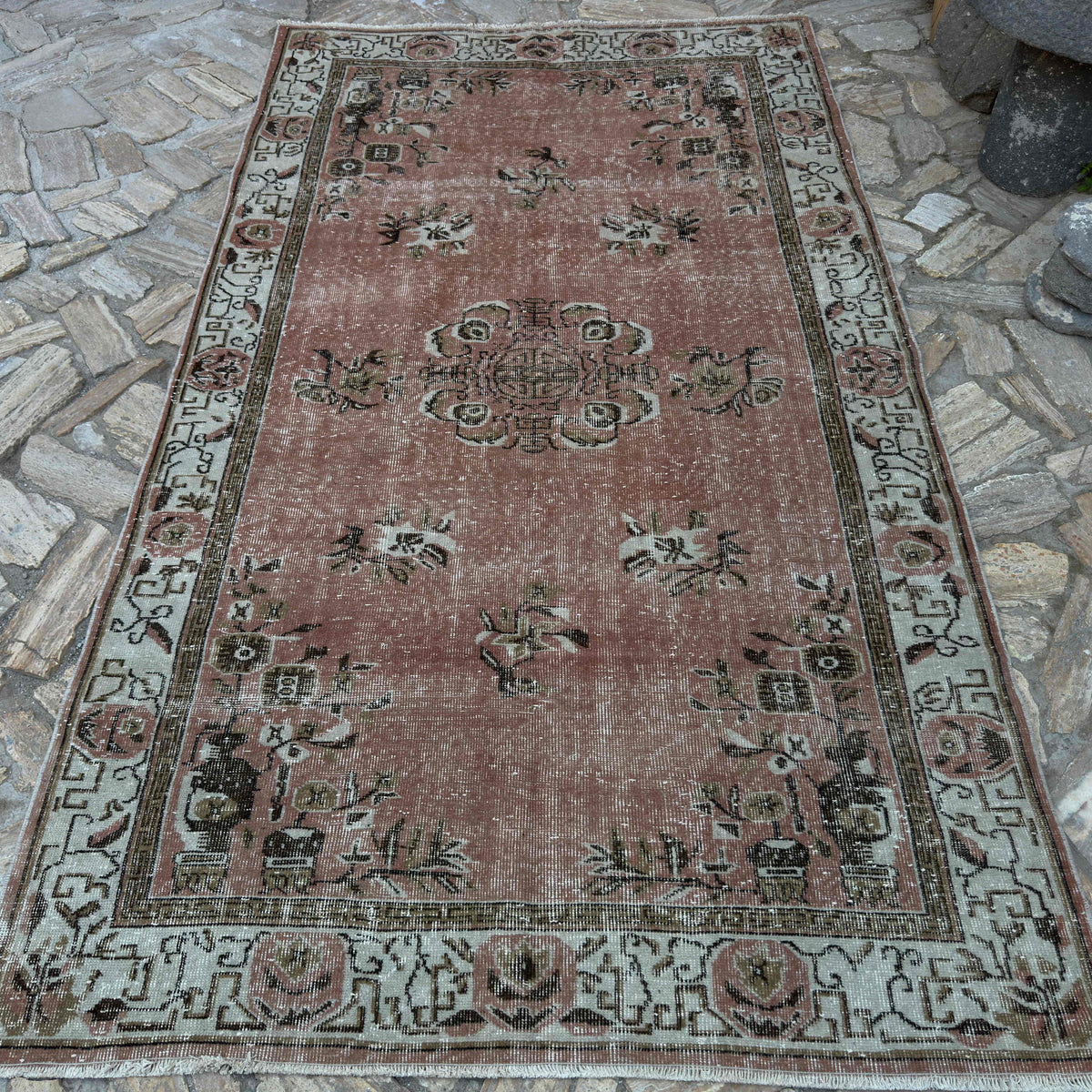 Pink 5' x 9' vintage Turkish geometric rug in wool and cotton, shown on the floor.
