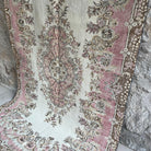 Pink 5' x 9' vintage Turkish geometric rug in wool and cotton, shown on the floor.