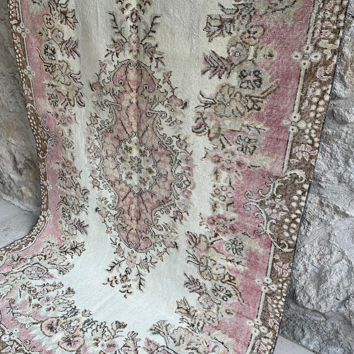 Pink 5' x 9' vintage Turkish geometric rug in wool and cotton, shown on the floor.