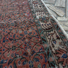 Close-up of the red vintage Turkish geometric rug showing floral details, hand-knotted weave, wool and cotton and low pile.