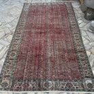 Red 5' x 9' vintage Turkish geometric rug in wool and cotton, shown on the floor.