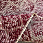 Close-up of the red vintage Turkish geometric rug showing floral details, hand-knotted weave, wool and cotton and low pile.