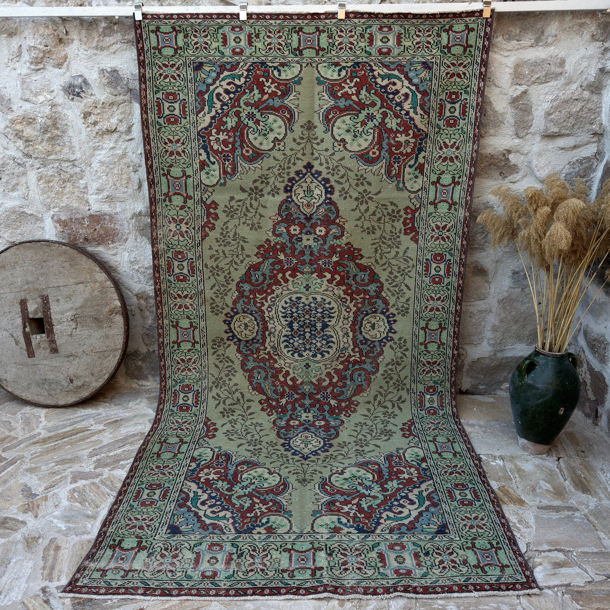 Green 6' x 11' vintage geometric rug with medallion design, handmade in Turkey – Laina.