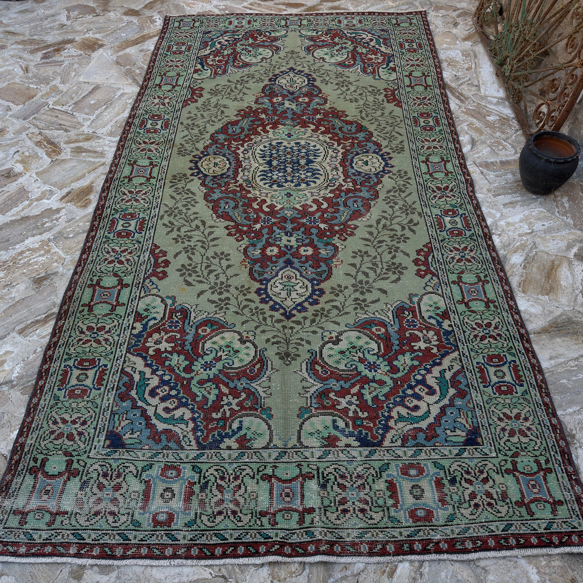 Green 6' x 11' vintage Turkish geometric rug in wool and cotton, shown on the floor.