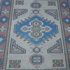 Close-up of the beige vintage Turkish geometric rug showing geometric details, hand-knotted weave, wool and low pile.