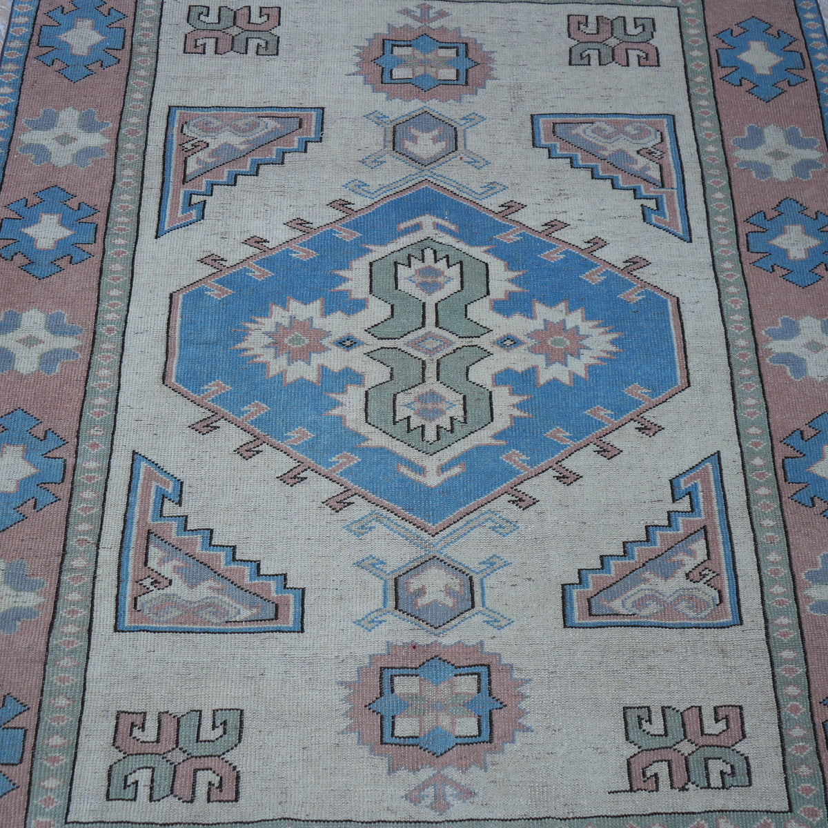 Close-up of the beige vintage Turkish geometric rug showing geometric details, hand-knotted weave, wool and low pile.