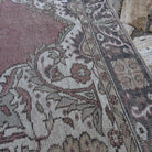 Close-up of the pale red vintage Turkish geometric rug showing medallion details, hand-knotted weave, wool and cotton and low pile.