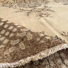 Close-up of the brown vintage Turkish geometric rug showing medallion details, hand-knotted weave, wool and cotton and low pile.