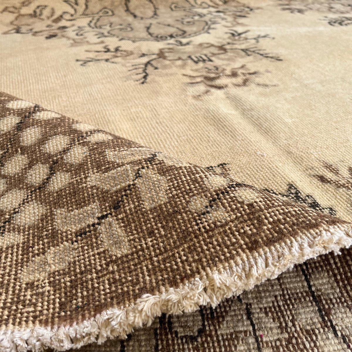 Close-up of the brown vintage Turkish geometric rug showing medallion details, hand-knotted weave, wool and cotton and low pile.