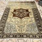 Brown 7' x 9' vintage Turkish geometric rug in wool and cotton, shown on the floor.