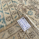 Close-up of the blue vintage Turkish geometric rug showing medallion details, hand-knotted weave, wool and cotton and low pile.
