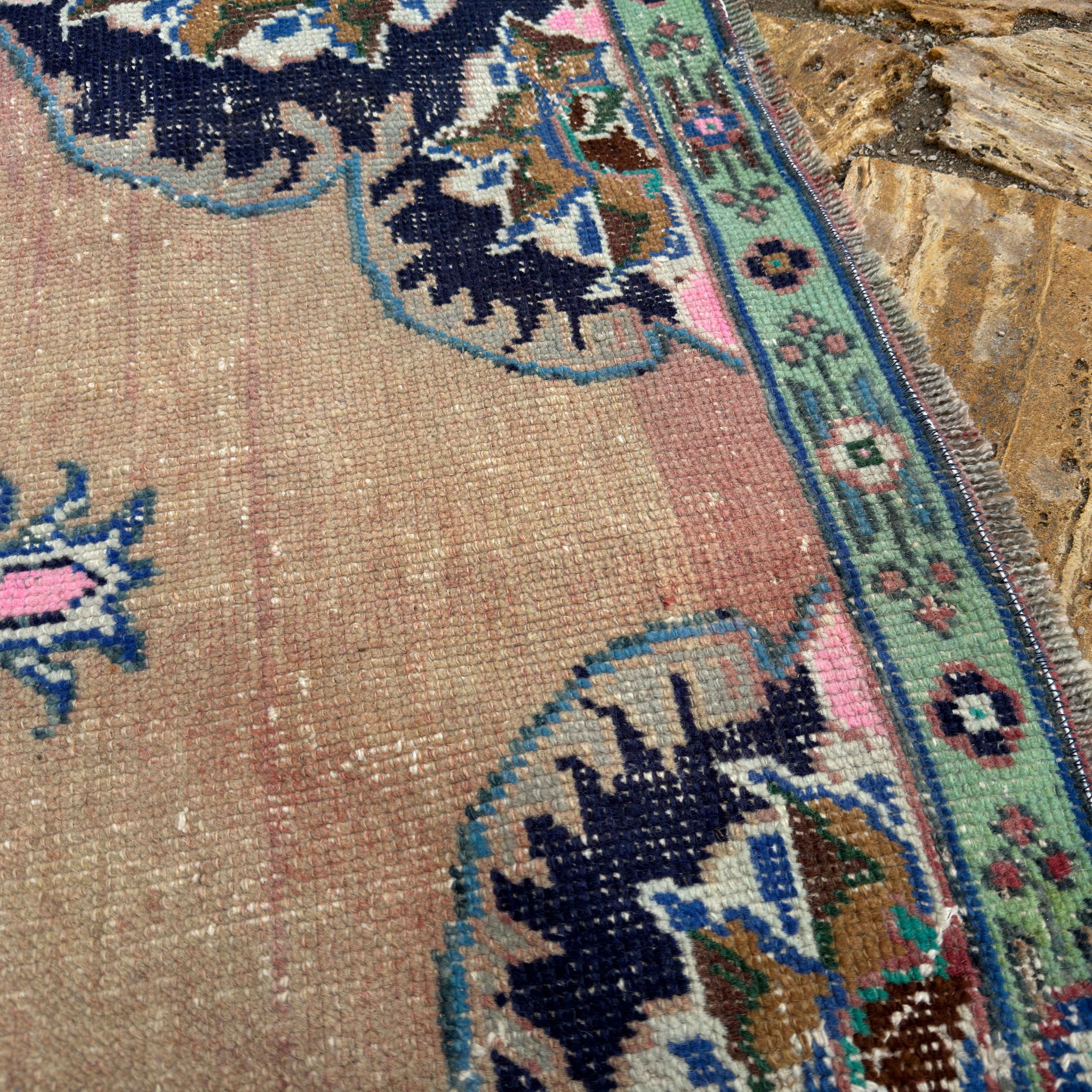 Close-up of the pale red vintage Turkish geometric runner rug showing traditional details, hand-knotted weave, wool and cotton and low pile.