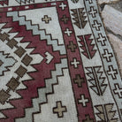 Close-up of the red vintage Turkish geometric runner rug showing neutral details, hand-knotted weave, wool and cotton and low pile.