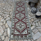 Red 3' x 9' vintage Turkish geometric runner rug in wool and cotton, shown on the floor.