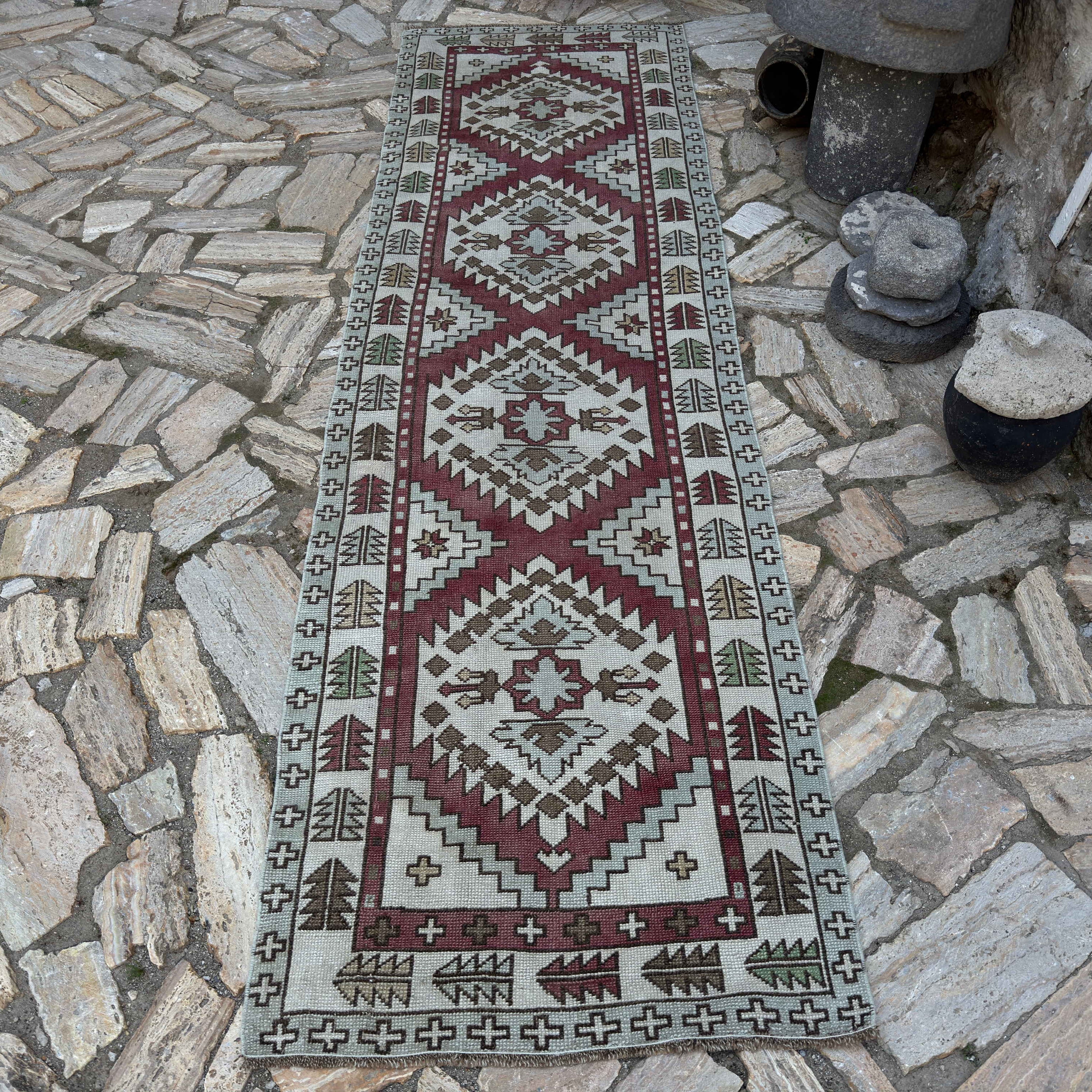 Red 3' x 9' vintage Turkish geometric runner rug in wool and cotton, shown on the floor.