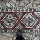 1970s red vintage Turkish geometric runner rug with neutral design, hand-knotted weave and low pile.