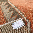 Close-up of the pale orange vintage Turkish geometric runner rug showing geometric details, hand-knotted weave, wool and cotton and low pile.