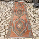 Pale Orange 4' x 12' vintage Turkish geometric runner rug in wool and cotton, shown on the floor.