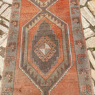 1970s pale orange vintage Turkish geometric runner rug with geometric design, hand-knotted weave and low pile.