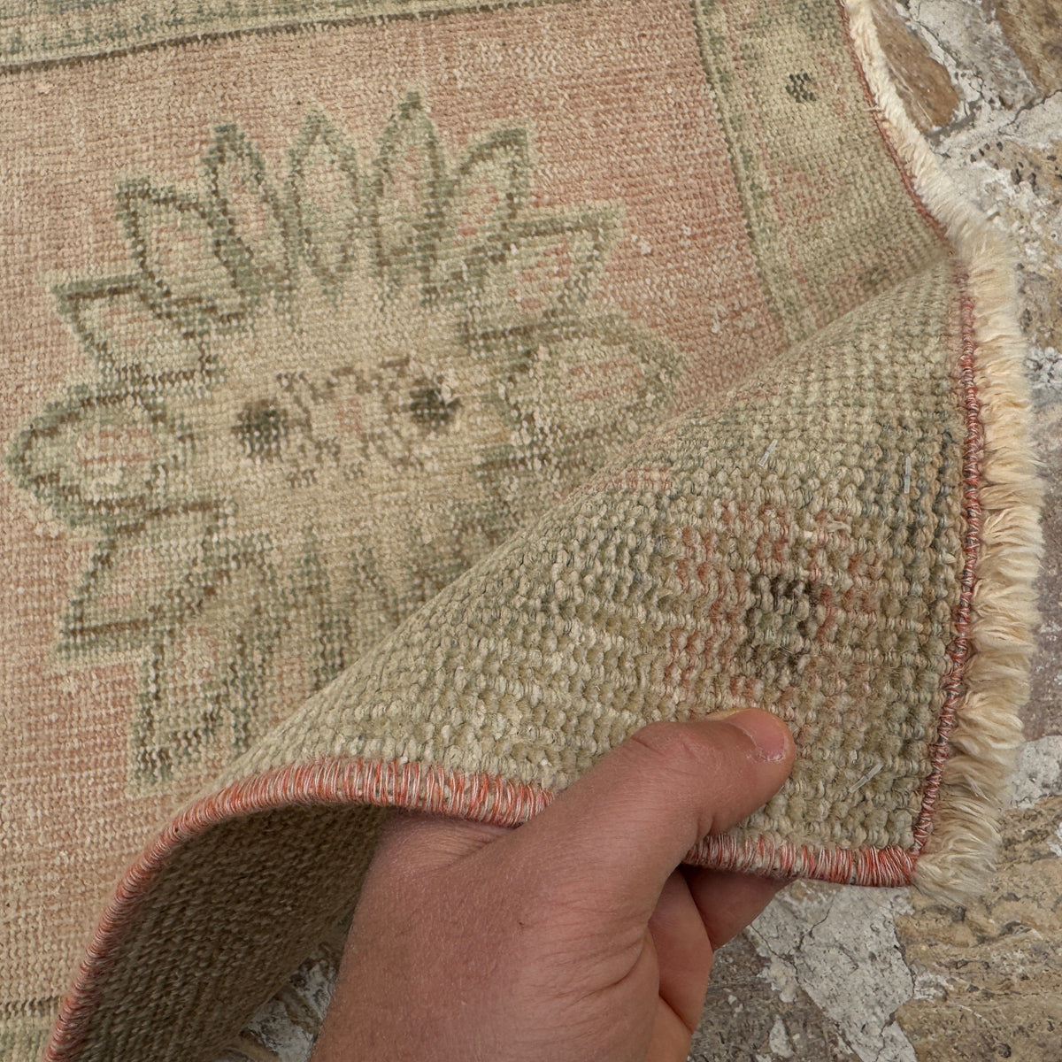 Close-up of the pink vintage Turkish handmade runner rug showing medallion details, hand-knotted weave, wool and cotton and low pile.