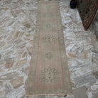 Pink 2' x 10' vintage Turkish handmade runner rug in wool and cotton, shown on the floor.