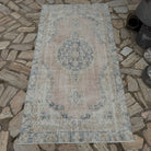 Pale Pink 3' x 6' vintage Turkish isparta rug in wool and cotton, shown on the floor.
